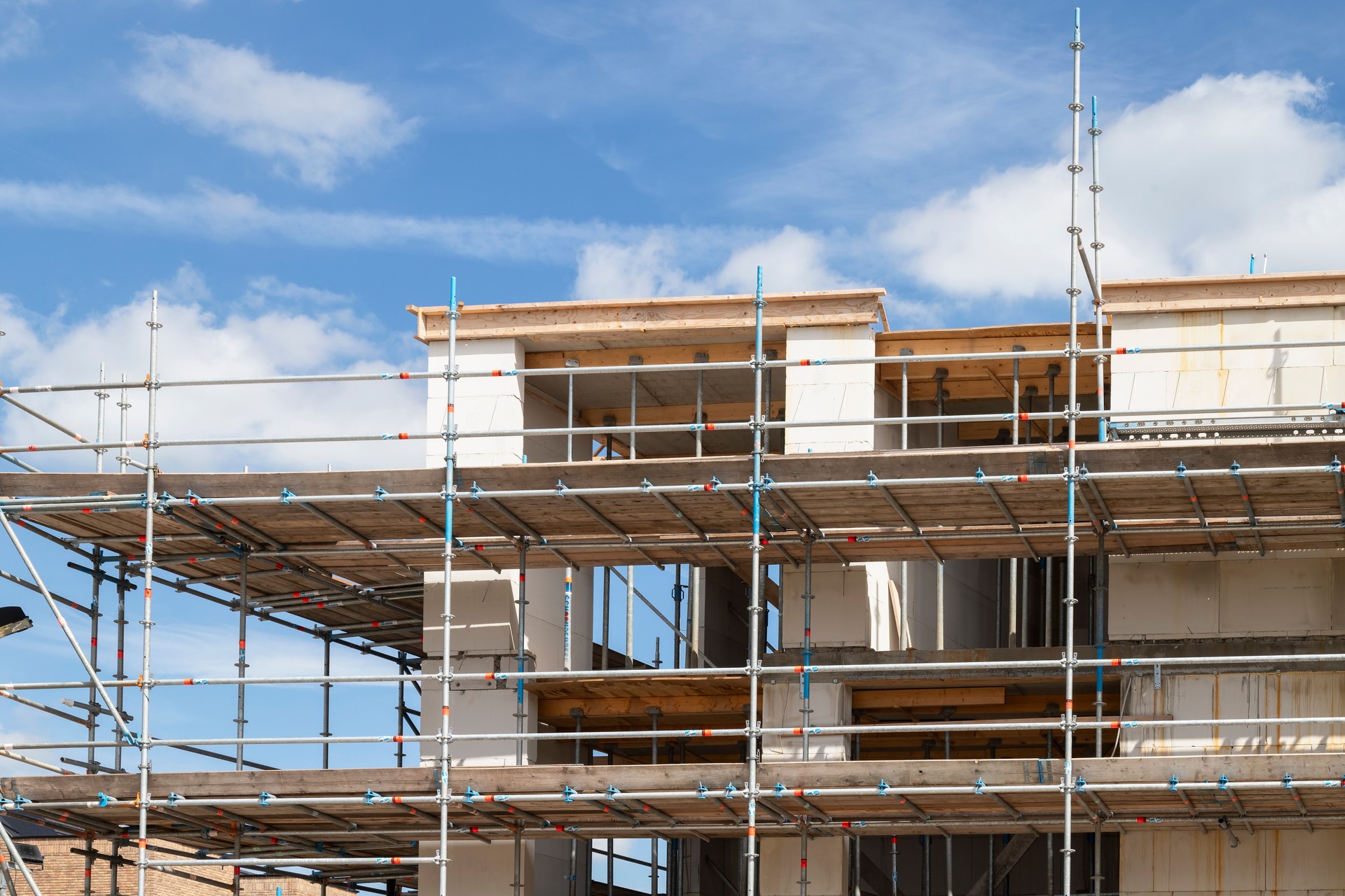 New-build apartment in scaffolding on a construction site of a new residential area.